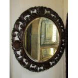 An early 20th century circular wall mirror with bevelled edge plate within a pierced scrolling and