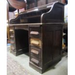 An early 20th century oak kneehole twin pedestal roll top desk, the S shaped tambour roll now