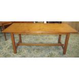 A pine kitchen table with rectangular top, raised on square cut and chamfered legs united by a