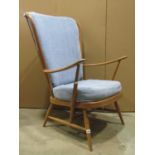 An Ercol medium to light beechwood Windsor winged and stick-back armchair, with swept arms, loose