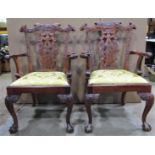 A pair of reproduction Chippendale style mahogany open armchairs, with moulded and scrolled