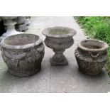 A weathered Georgian style garden urn, the shallow circular bowl raised on a combined square stepped