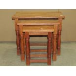 A nest of three good quality oak graduated occasional tables in the old English style, the