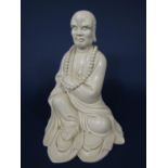 A large cream glazed oriental figure of a Lohan in seated pose with impressed seal mark to