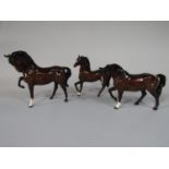 Three Beswick brown glazed horses, each with raised foreleg (3)