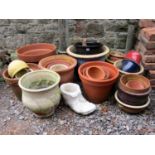 A quantity of mainly contemporary but some weathered terracotta outsized flower pots/planters,