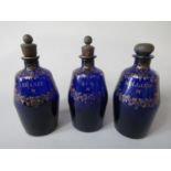 Three good quality blue glass decanters, with gilt overlay decoration for Brandy, Rum and