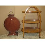 An art deco floorstanding walnut etagere on three oval graduated tiers, with well matched quarter