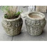 A pair of weathered composition stone garden urns of shouldered form with moulded ring handles and