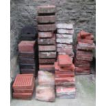 A quantity of weathered terracotta paving and air bricks, segmented and stacked in varying shapes