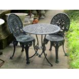 A cast aluminium garden terrace table of circular form with decorative pierced top raised on swept