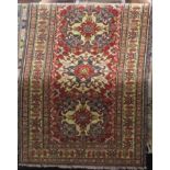 Persian three medallion rug upon a red ground, together with a further three medallion rug on a