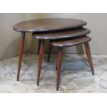 A nest of three Ercol dark stained elm and beechwood 'Pebble' occasional tables, raised on splayed