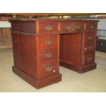 A small late Victorian walnut kneehole twin pedestal writing desk with faux inset leather panelled