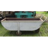 A vintage agricultural galvanised steel three wheeled feed barrow with six feet long body approx