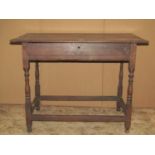 An antique oak side table, with shallow frieze drawer raised on turned supports, united by