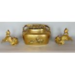 Two Chinese cast brass dogs of fo and a hand warmer with hinged handle (3)
