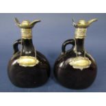 A pair of antique brown glass flask decanters with silver plated lids and scallop shell thumb