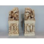 A pair of Chinese carved soapstone dogs of fo seals, mounted by various carved dogs upon temple