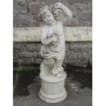 A garden figure of a cherub holding fruiting vines, raised on a circular fluted plinth, 83cm high