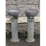 A pair of Georgian lead urns of circular form with rope twist borders, raised on lion supports, on