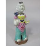 An unusual oriental figure of a standing boy in polychrome painted suit (with restoration) 19.5cm