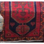 Good quality full pile Afghan runner, with bold central green medallion upon a washed red and blue