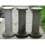 Three weathered composition stone cylindrical fluted columns/pedestals with decagon bases, 53 cm