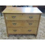A small late Victorian stripped pine bedroom chest of three graduated drawers, with cast brass