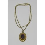 19th century yellow metal cabochon garnet pendant with wirework detail and glazed compartment verso,