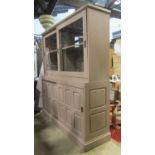 A two sectional side cabinet/dresser enclosed by two pairs of sliding panelled doors, the upper