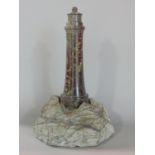 A carved serpentine study of a lighthouse, 20cm high (chips to top layer)
