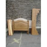 A continental stripped and waxed pine single bedstead, the panelled and arched head and foot