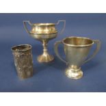 A mixed collection of silver comprising two twin handled trophies and a further bottle sleeve