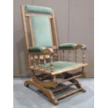 An Edwardian rocking chair, with moulded frame, upholstered pad seat, back and arms