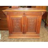 A 19th century carved oak side cupboard/buffet with portrait panels, scrolling acanthus and face