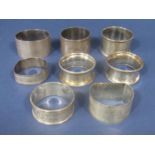 Eight various silver napkin rings to include a modern textured cast silver example, 6oz approx