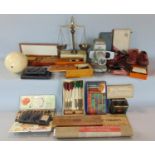 A box of interesting items comprising various gaming items, darts, etc, set of postal scales,