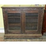 A 19th century side cupboard enclosed by a pair of glazed panelled doors, enclosing shelves,