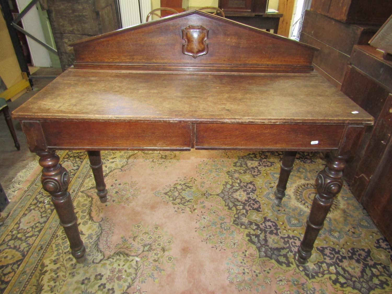 Mid-Victorian oak serving table of rectangular form, enclosing two frieze drawers, raised on four