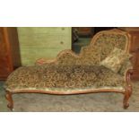 A Victorian mahogany framed chaise lounge, with carved and scrolled detail on cabriole supports