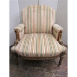 A French armchair with carved and gilded show wood frame, with reeded and spiral twist supports,
