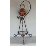 A Victorian ironwork kettle stand with spiral twist supports, supporting brass and copper kettle