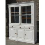 A pine two sectional kitchen dresser with painted and distressed finish, enclosed by a pair of