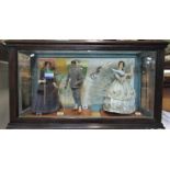 A counter top display case containing three figures, two female, one male, in period costume, with