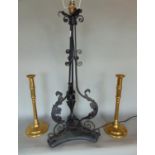 A pair of early 19th century brass column candlesticks, 33cm high, together with a wrought iron lamp