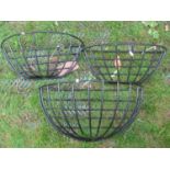 Three graduated coated wire work wall mounted bow fronted flower baskets, the largest 56 cm long x
