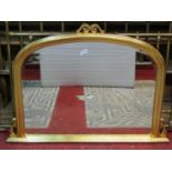 A contemporary Victorian style overmantel mirror with bevelled edge plate within a gilt arched and