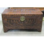A small eastern camphor wood chest with hinged lid and profusely carved detail and stepped bracket