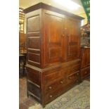 An 18th century oak livery cupboard in two sections, the upper section enclosed by a pair of